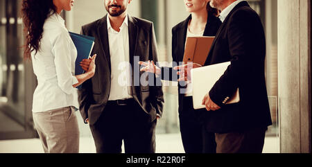 Geschäftsleute, die sich in einer Diskussion im Büro Flur Stockfoto
