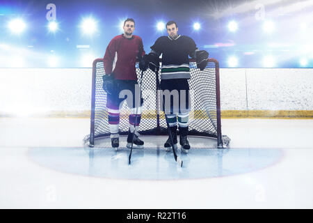 Das zusammengesetzte Bild im Eishockey Spieler durch Ziel post stehend Stockfoto