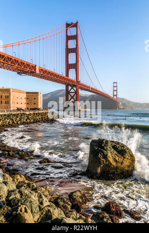 Surfers fangen früh morgens Wellen unter der Golden Gate Bridge in der Nähe von Fort Point bei der Eröffnung der San Francisco Bay an den Pazifischen Ozean. Stockfoto