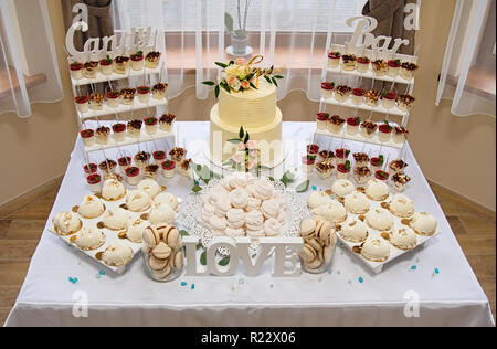 Candy Bar. Hochzeitstorte von Blumen stehen der festlichen Tisch mit Wüsten eingerichtet Stockfoto