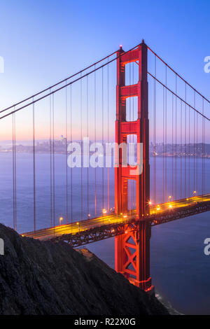 Der Nordturm der legendären Golden Gate Bridge steht, die durch die Stadt von San Francisco gesichert kurz vor Sonnenaufgang. Stockfoto