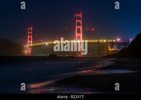 Wahrzeichen von San Francisco Golden Gate Bridge ist von Baker Beach nach Einbruch der Dunkelheit gesehen. Stockfoto