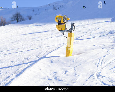 Gelber Schnee Kanone auf die Skipisten. Künstliche Beschneiung Maschine in warmen Winter verwendet die Schneedecke zu mantein Stockfoto