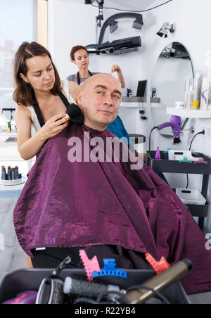 Nach kahl männlichen Klienten empfangen von Dienst, der von Professional Friseur im Salon Stockfoto