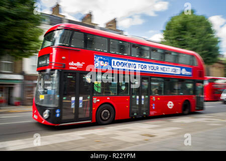 Panning Bild von einem roten Doppeldeckerbus, wie es entlang einer Straße in London reisen, Großbritannien Stockfoto