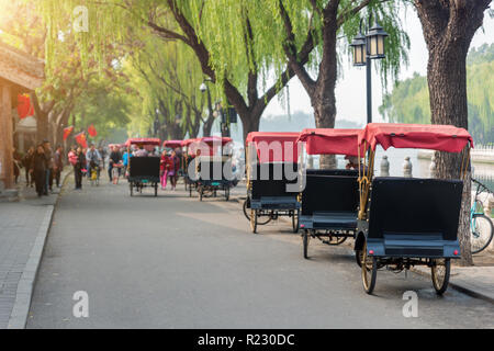 Touristen reiten Peking traditionelle Rikscha im alten China Hutong in Peking, China. Stockfoto