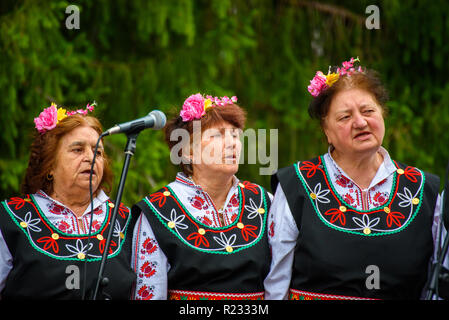 Gruppe von Frauen in der traditionellen bulgarischen Volkstrachten - singen ein Lied zu einem Musikfestival in der kleinen Stadt Apriltsi, Bulgarien. Stockfoto