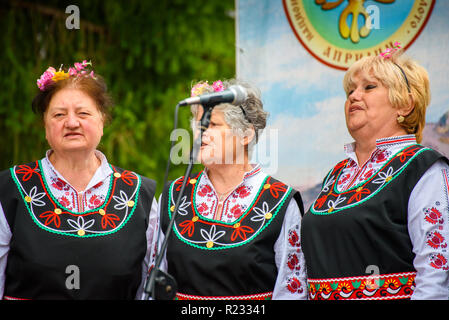 Gruppe von Frauen in der traditionellen bulgarischen Volkstrachten - singen ein Lied zu einem Musikfestival in der kleinen Stadt Apriltsi, Bulgarien. Stockfoto