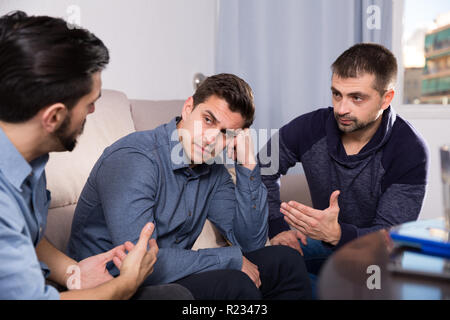 Zwei gestörte Männer, ernstes Gespräch mit ihrem Freund zu Hause Stockfoto