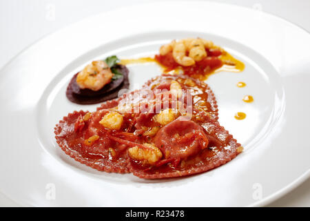 Herzförmige frisch gefüllte Pasta mit Garnelen Sahne gekleidet. Valentinstag Festliche Schale. Stockfoto