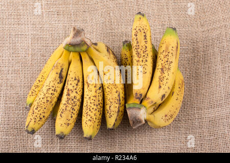 Bündel gelb sommersprossige Bananen auf einer Leinwand Textur Stockfoto
