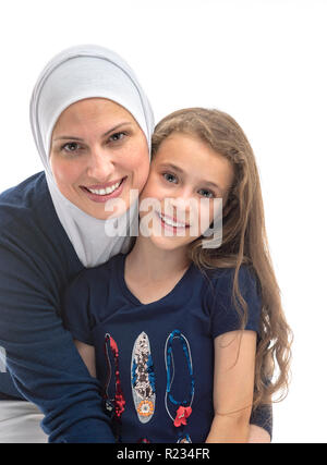 Happy muslimische Mutter umarmte ihre Tochter isoliert auf weißem Stockfoto