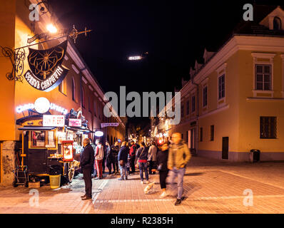 Brasov, Rumänien - 21. Oktober 2018: Die überfüllten Altstadt von Brasov in der Nacht, mit der Stadt anmelden Tampa Mountain beleuchtet Stockfoto