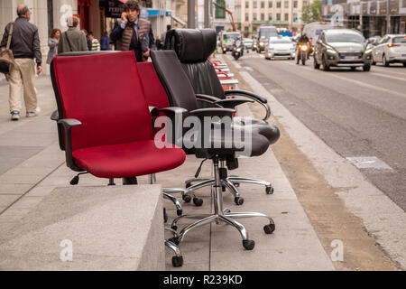 Bürostühle auf dem Bürgersteig an der Gran Via, Madrid, Spanien Stockfoto