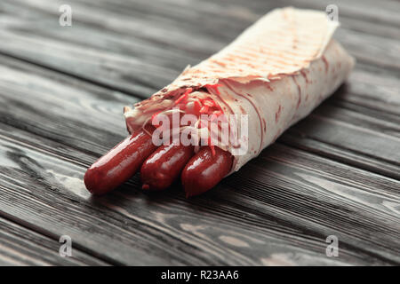 Würzige Wurst in pita Brot auf hölzernen Hintergrund Stockfoto