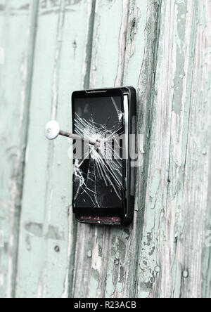 Veraltete Handy ist mit einem hölzernen Zaun genagelt Stockfoto