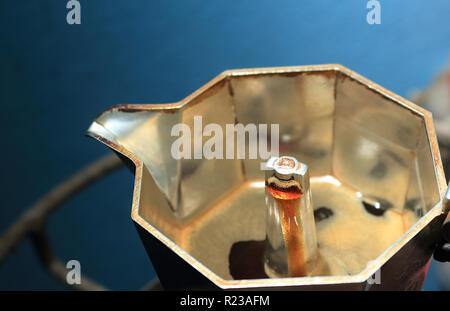 Der italienische Moka-Topf bereitet Kaffee zu, und das Getränk fängt an zu fließen. Stockfoto
