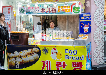 Eine Dame mans ihr Street Food in Myeongdong in Seoul, Südkorea. Stockfoto