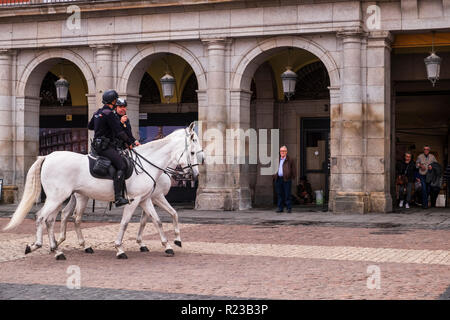 Berittene Polizei auf Reiten durch die Plaza Mayor, Madrid, Spanien Stockfoto