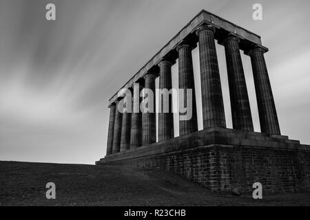 Wolken verschwimmen, wie Sie Schlag auf Calton Hill und die unvollendete National Monument von Schottland in Edinburgh in der Nacht. Stockfoto