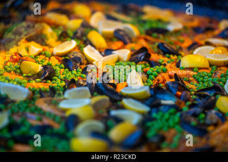 Spanische Paella mit Huhn, Muscheln, Garnelen, Garnelen und Chorizo Wurst in traditionellen Pan in der Nähe in einem Lebensmittelmarkt
