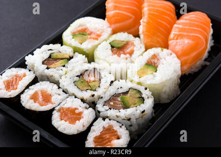 Sushi Pack mit Nigiri und Maki auf schwarzem Hintergrund Stockfoto