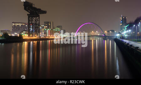 Glasgow, Schottland, Großbritannien - 5 November, 2018: den Fluss Clyde Clyde Arc fließt unter der Brücke und vorbei an den Sehenswürdigkeiten Finnieston Kran in der Nacht in Glasgow. Stockfoto