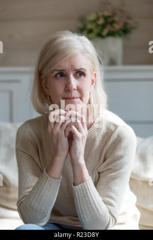 Verärgert alte Dame weinend auf der Couch sitzt allein zu Hause, traurig gealterte Frau in Distanz zu übergeben Mann vermissen ihn denken suchen, nachdenkliche Senior Stockfoto