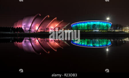 Glasgow, Schottland, Großbritannien - 4. November 2018: Die MODERNISTISCHE SEC Armadillo Auditorium und SSE Hydro Arena in der Nacht beleuchtet sind und sich in den Fluss Clyde Stockfoto