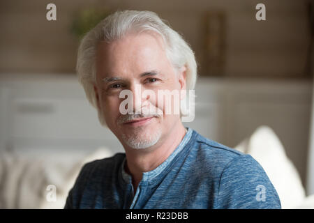 Close up Portrait von lächelnden alter Mann mit Schnurrbart auf Kamera zu Hause entspannen suchen, gerne älteren männlichen posing Aufnahmen in Innenräumen, älteren Mann ma Stockfoto