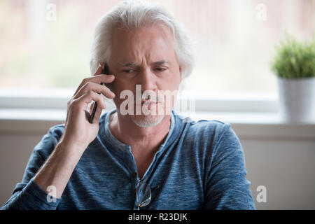 In der Nähe von schweren alter Mann am Telefon sprechen von zu Hause aus, nachdenklich älterer männlichen Sprechen über Handy, in der Diskussion mit Kollegen, ältere Menschen mit sm Stockfoto