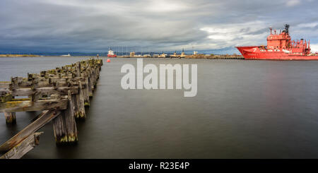 Edinburgh, Schottland, Großbritannien - 3. November 2018: Fracht- und Industrial Engineering ships Dock neben einem alten verfallenen und verlassenen hölzernen Pier in Edinburgh Stockfoto