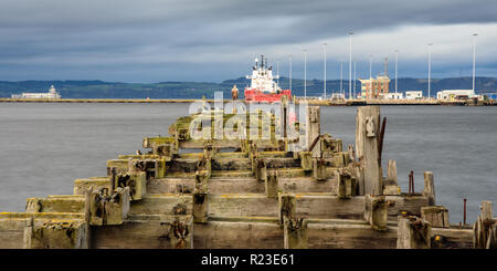 Edinburgh, Schottland, Großbritannien - 3. November 2018: Seevögel und eine Antony Gormley Statue stehen auf einer verfallenen und verlassenen Pier in Leith Docks, mit Westlichen Stockfoto