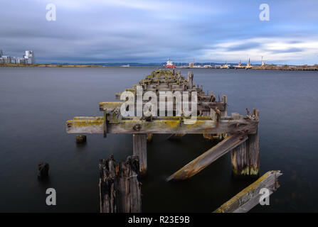 Edinburgh, Schottland, Großbritannien - 3. November 2018: Fracht- und Industrial Engineering ships Dock neben einem alten verfallenen und verlassenen hölzernen Pier in Edinburgh Stockfoto