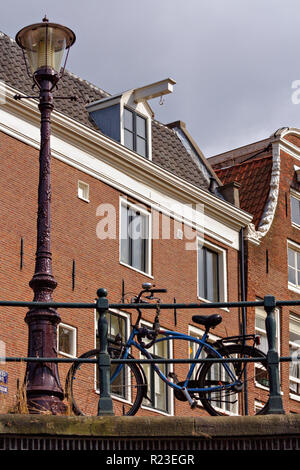 Typische Straße in der Innenstadt von Amsterdam mit dem alten Fahrrad in der Front. Stockfoto