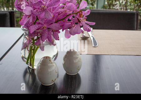 Salz- und Pfefferstreuer vor wunderschöne Orchideen Stockfoto