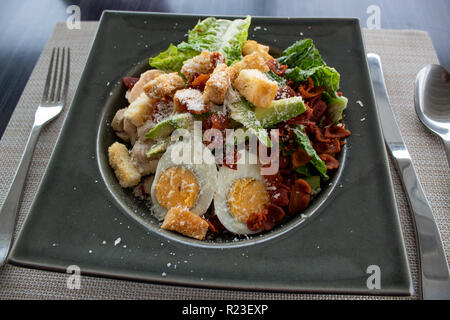 Caesar Salat mit Ei, Avocado, Croutons, Speck und Käse Stockfoto