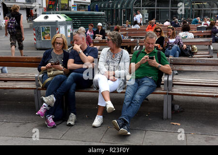 Leute sitzen auf öffentliche Sitzbänke Wien, Österreich Stockfoto