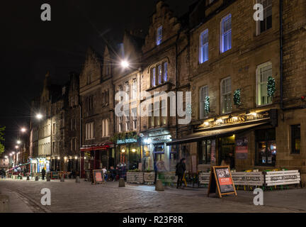 Edinburgh, Schottland, Großbritannien - 2 November, 2018: Börsenspekulanten trinken außerhalb der Kneipen und Bars entlang der Grassmarket Edinburgh traditionelle gepflasterten Straße bei Nacht. Stockfoto