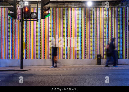 London, England, Großbritannien - 7. Oktober 2018: Fußgänger kreuz Ladbroke Grove Straße an einem fußgängerüberweg unter der Hammersmith und City London Underground Stockfoto