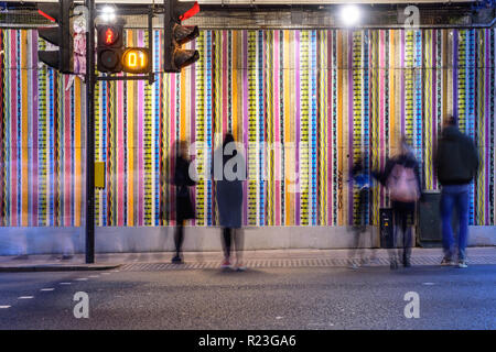 London, England, Großbritannien - 7. Oktober 2018: Fußgänger kreuz Ladbroke Grove Straße an einem fußgängerüberweg unter der Hammersmith und City London Underground Stockfoto