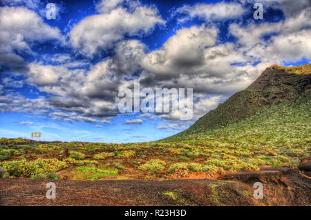 Wolken im blauen Himmel und grüne Felder mit Bergen an einem sonnigen Tag, Nordwestküste von Teneriffa in der Nähe von Punto Teno Leuchtturm, Canarias. Stockfoto