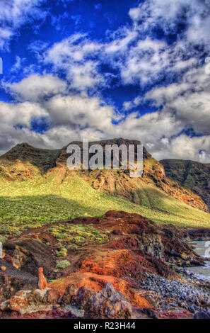 Wolken im blauen Himmel und grüne Felder mit Bergen an einem sonnigen Tag, Nordwestküste von Teneriffa in der Nähe von Punto Teno Leuchtturm, Canarias. Stockfoto