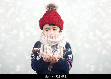 Kleines Kind bläst den Schnee von Hände in Weihnachten Stockfoto