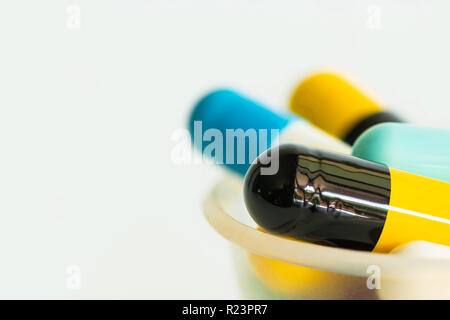Nahaufnahme von den bunten Pillen in einer Schale auf weißem Hintergrund Stockfoto