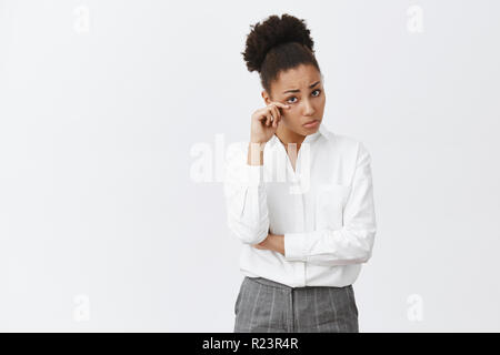 Mädchen Anhörung traurige Geschichte von Kollegen, Wischen von Träne, Gefühl der Traurigkeit und Kummer. Portrait von düsteren Afrikanisch-amerikanische weibliche Unternehmer in Pant Stockfoto