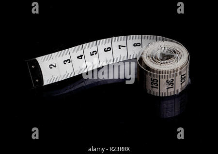 Tape measeure auf schwarzem Hintergrund. Stockfoto