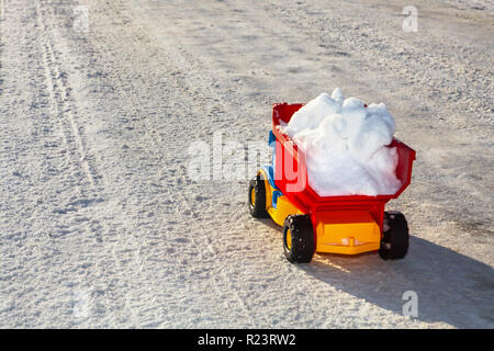 Spielzeug-LKW entfernt Schnee auf der Straße im Winter Stockfoto