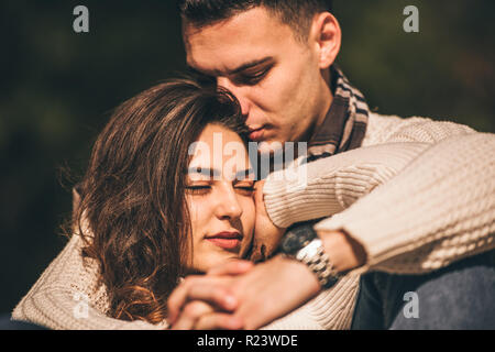 Göttliche Paar sitzt am Fluss im Park und verbringen die Zeit zusammen Stockfoto