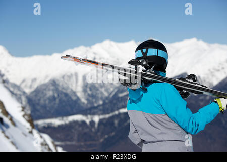 Foto von der Rückseite der sportliche Frau mit Skier auf die Schulter Stockfoto